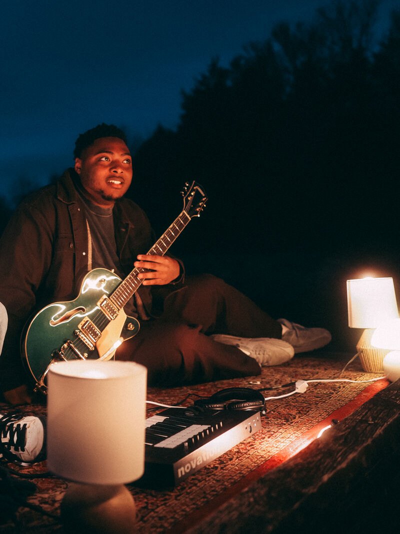 Sincer playing guitar at the lake