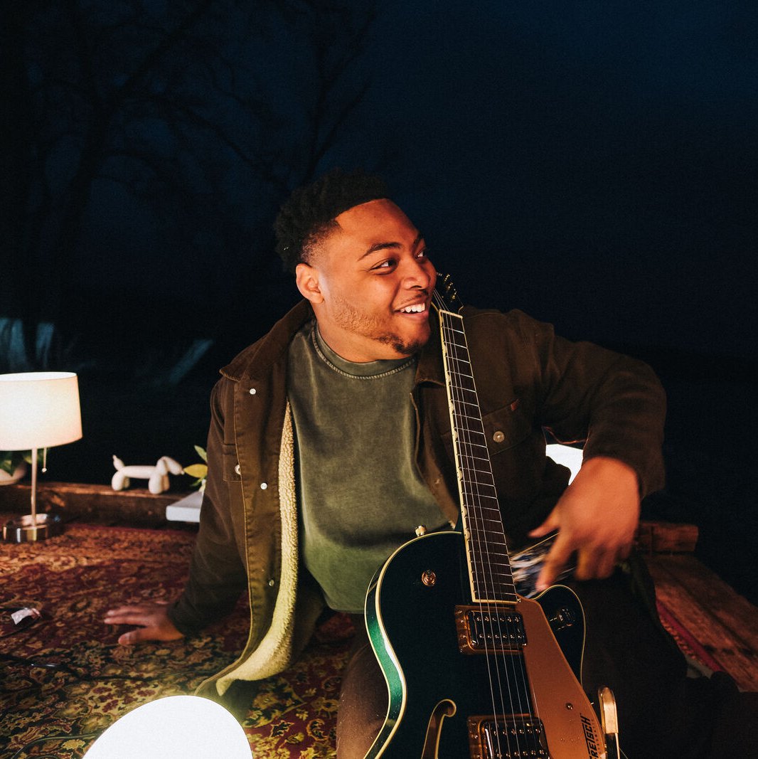 Sincer with his guitar by lamplight
